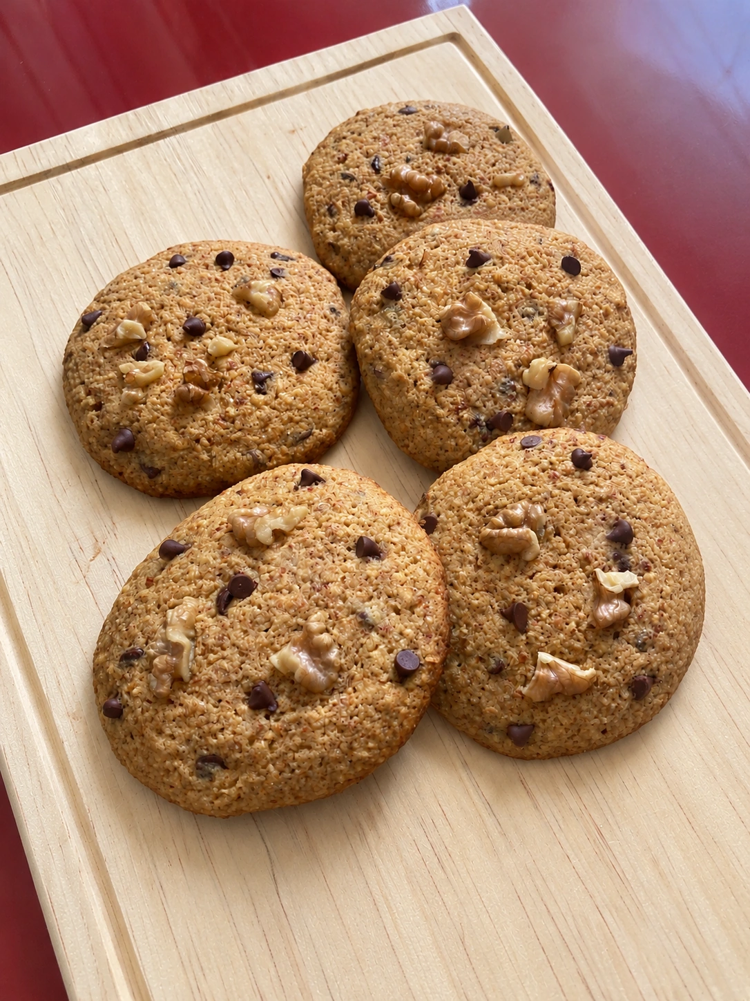Ketookies con chispas de chocolate y nueces sobre su tabla de madera